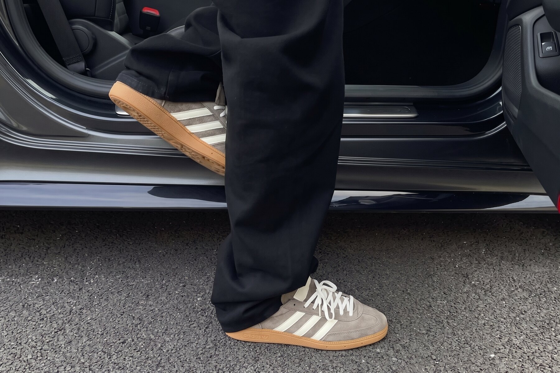 Clean suede trainers stepping out of a car